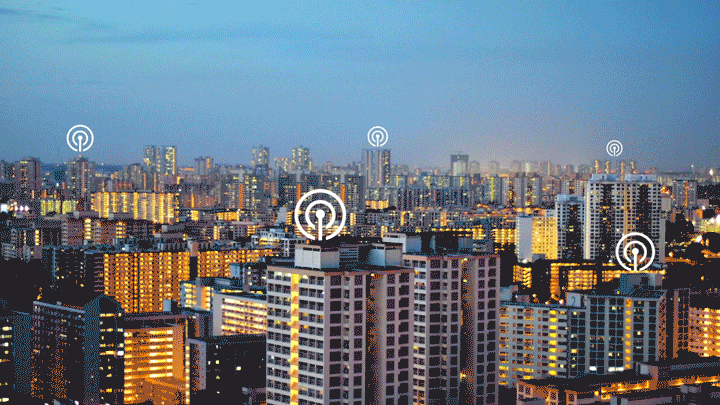 Singapore's cityscape at night, featuring network icons on buildings, representing Willowmore's IMDA-accredited keyless smart padlocks